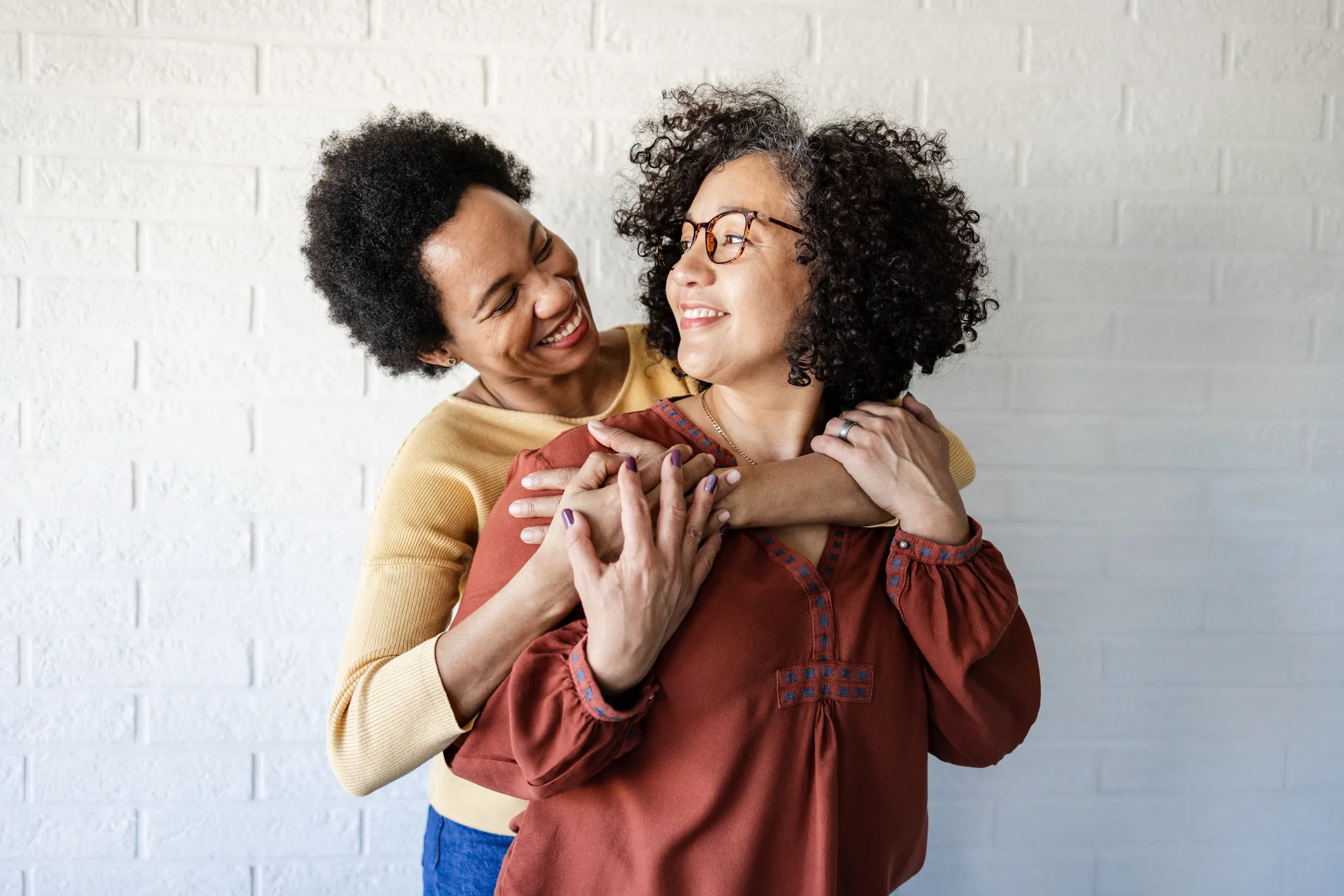 Two women embracing and talking about wellness care
